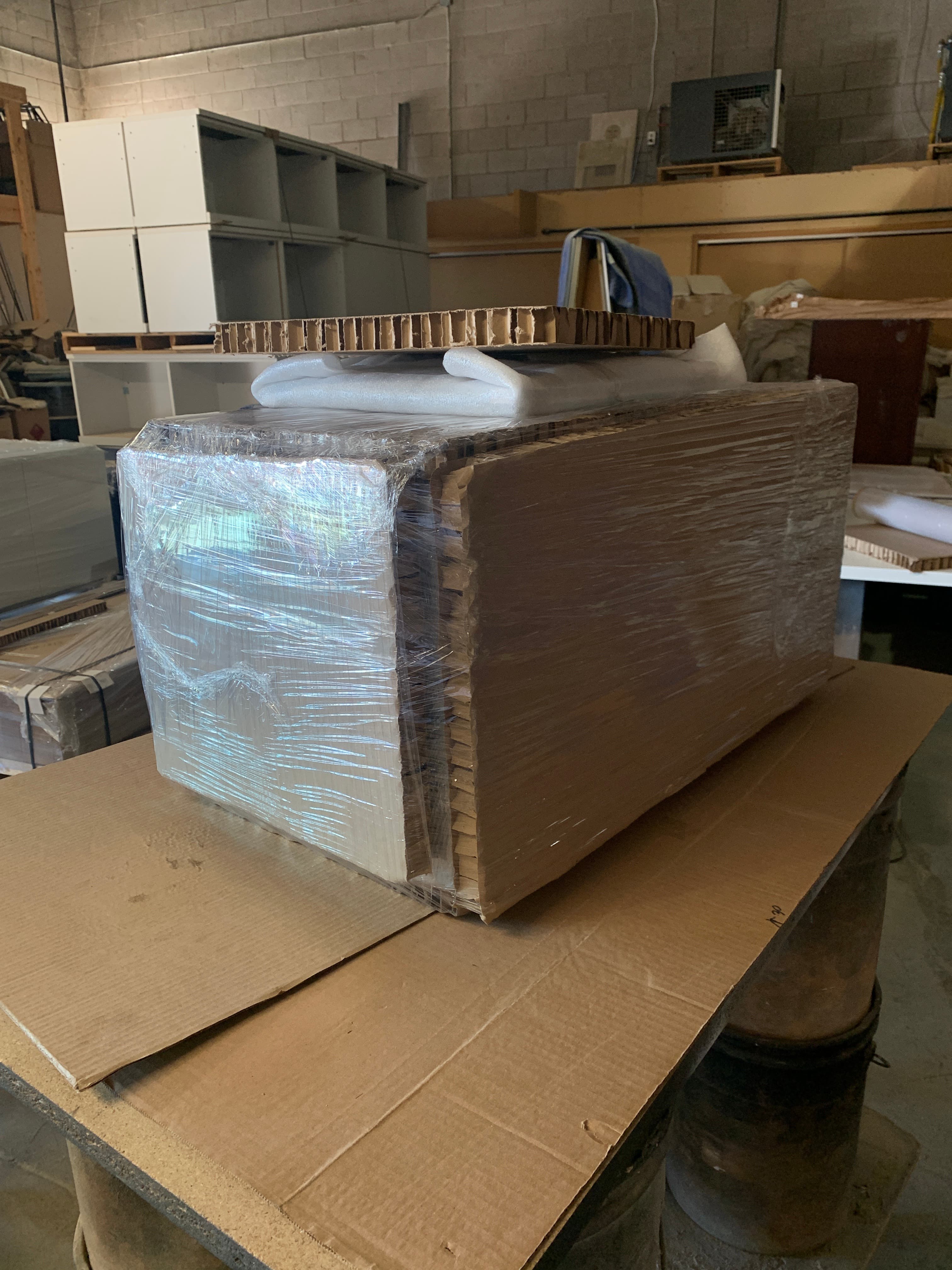 A product wrapped in honeycomb cardboard, foam sheeting and stretch film for surface protection.