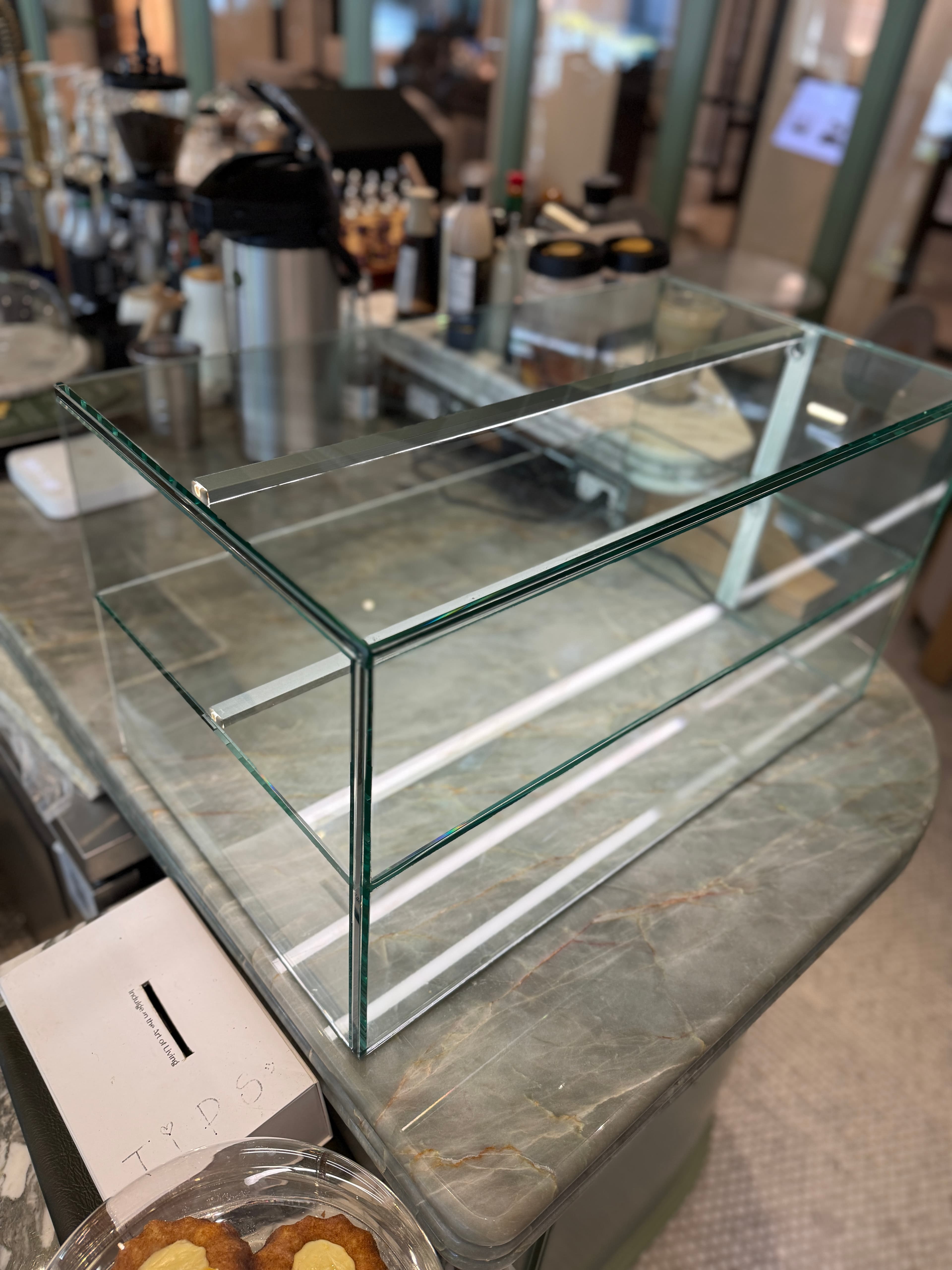Custom extra-clear glass display case with multiple shelves, installed in a chocolate shop